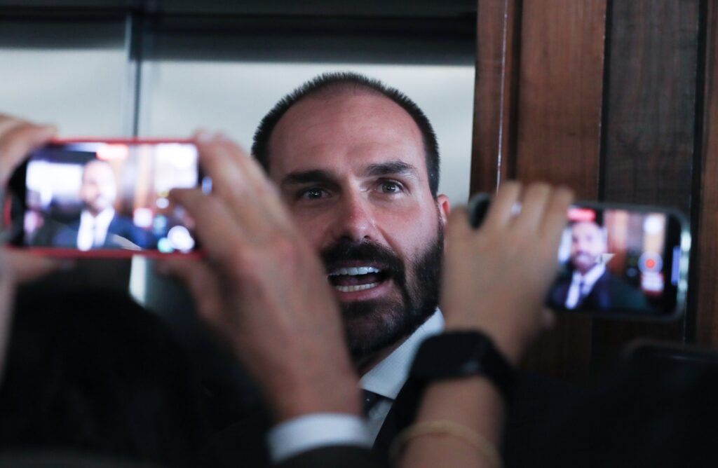 Eduardo Bolsonaro é filmado e fotografado por smartphones durante entrevista.