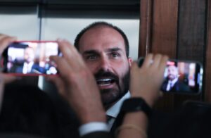 Eduardo Bolsonaro é filmado e fotografado por smartphones durante entrevista.