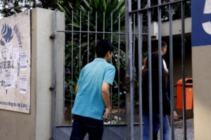 Pessoas entram por um portão metálico na UERJ para a realização de provas do Concurso Público Nacional Unificado.