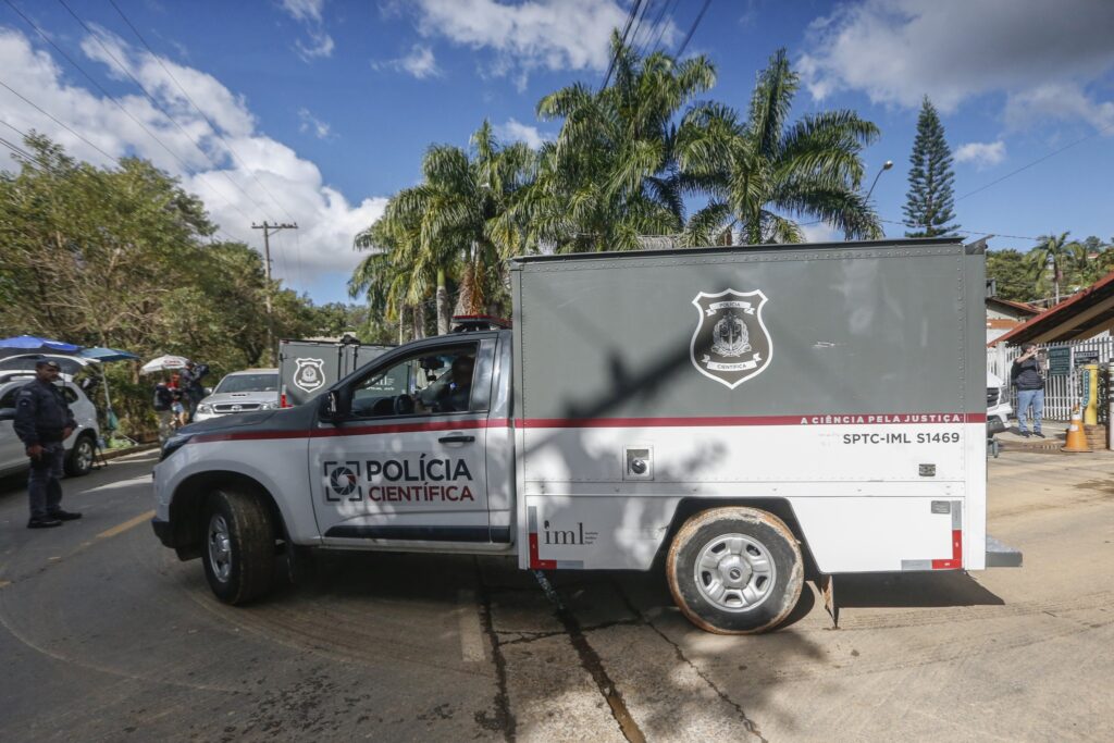 Veículo da Polícia Científica estacionado em via urbana com a inscrição "A CIÊNCIA PELA JUSTIÇA" e logotipo do IML.