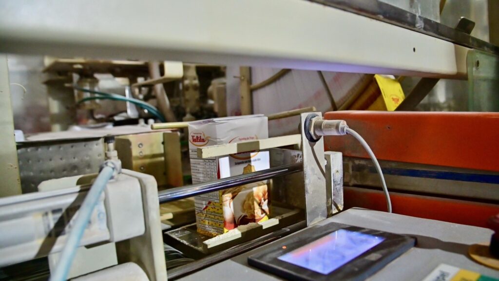 Embalagens de farinha de trigo da marca Talita em esteira de linha de produção industrial.
