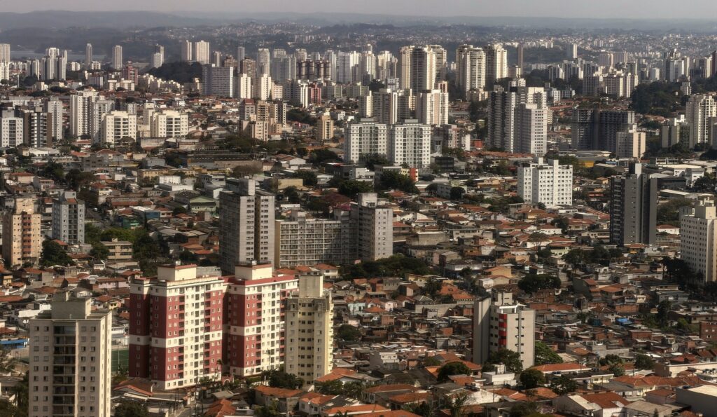 Vista aérea panorâmica da densa paisagem urbana de São Paulo, destacando edifícios e construções residenciais.