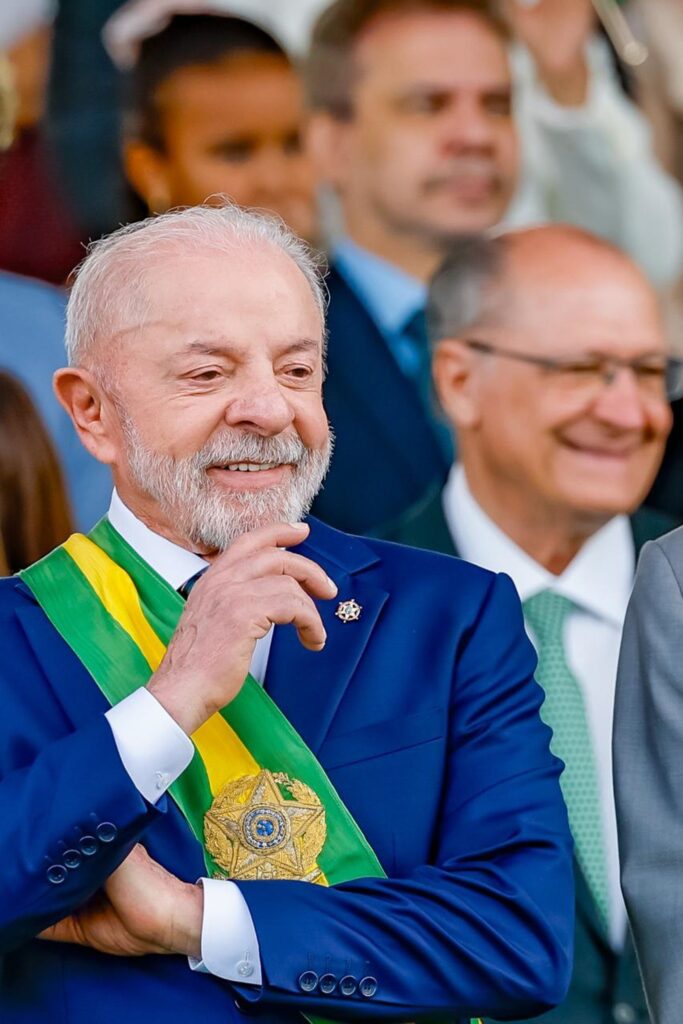 O presidente Luiz Inácio Lula da Silva veste terno e faixa presidencial durante evento público.
