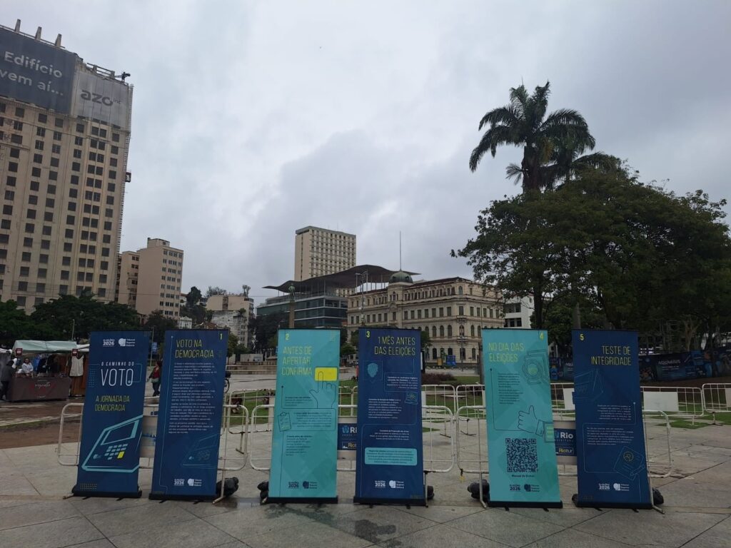 Exposição itinerante do Tribunal Superior Eleitoral com painéis informativos sobre o processo de votação nas "Eleições 2026", instalada em praça pública.
