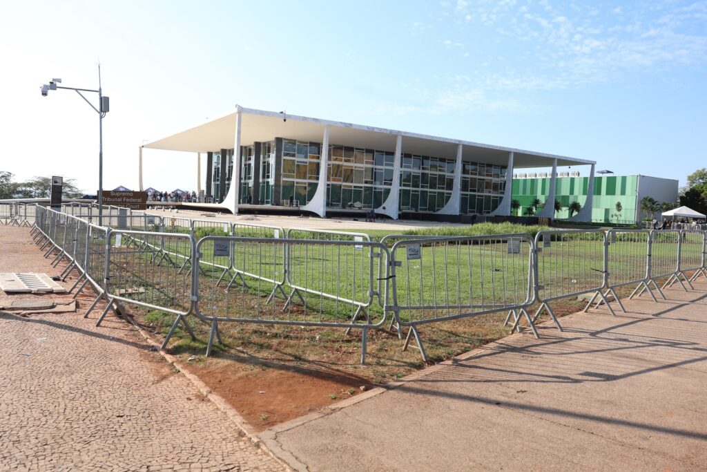 Fachada do edifício do Supremo Tribunal Federal cercada por grades metálicas de segurança.