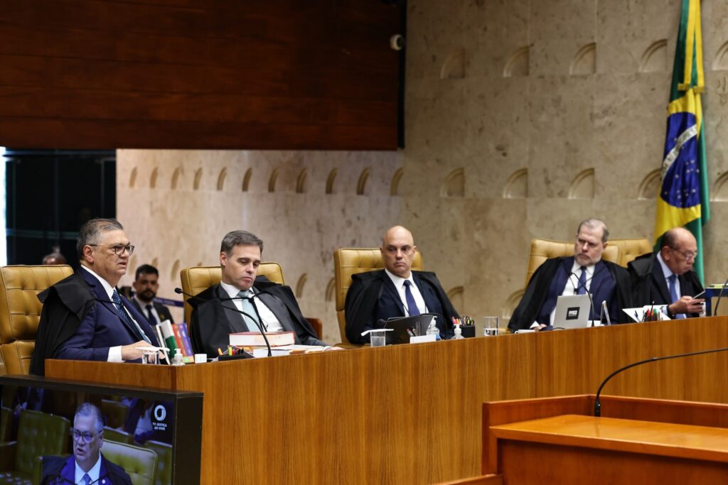 Ministros do STF sentados à bancada durante sessão plenária extraordinária, com Flávio Dino gesticulando à esquerda.