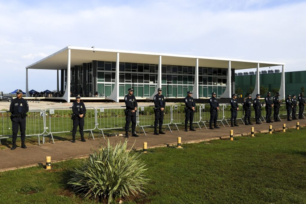 Policiais em uniformes escuros fazem a guarda em frente à fachada do Supremo Tribunal Federal.
