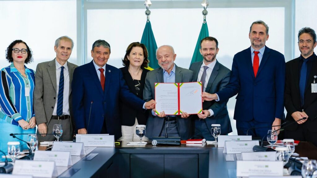 Presidente Lula e autoridades seguram pasta com documento durante anúncio de atualização monetária do "Bolsa Família".
