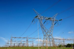 leilao da aneel: Torres de alta tensão e subestação de energia elétrica sob céu azul.