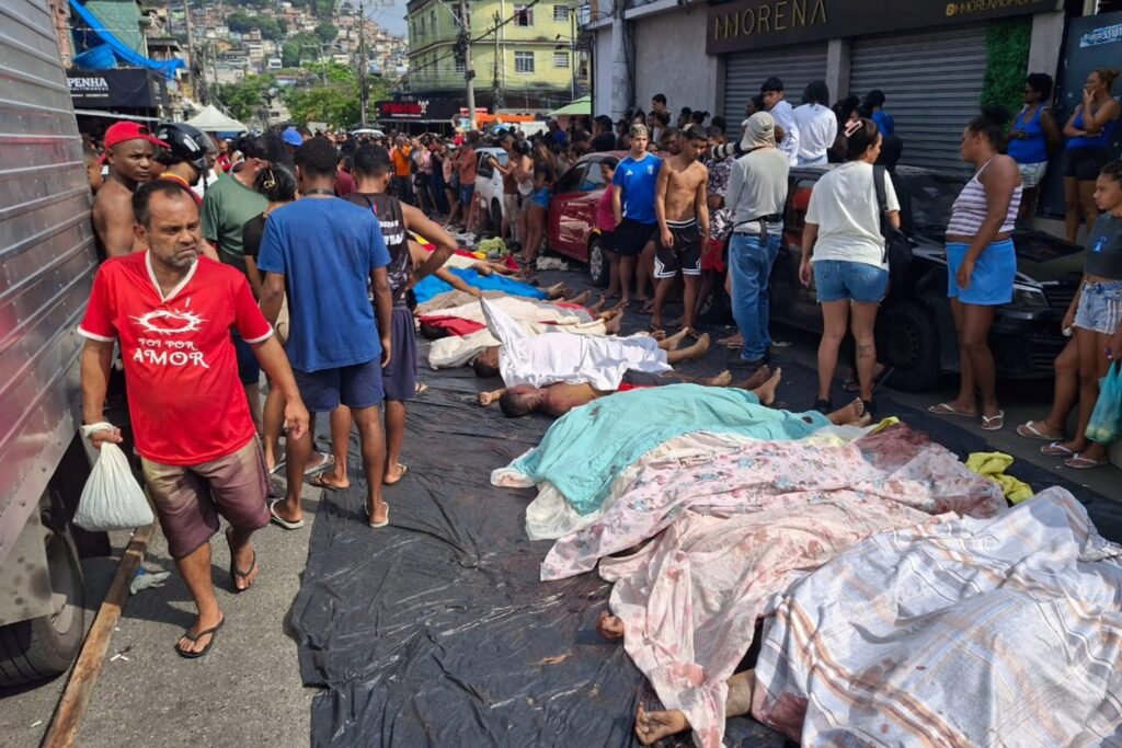 Operação Contenção: corpos cobertos por lençóis em rua urbana na Penha, Rio de Janeiro.