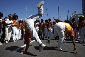 Operação Contenção: Duas mulheres participam de manifestação com movimentos de capoeira na rua durante ato público no Rio de Janeiro.