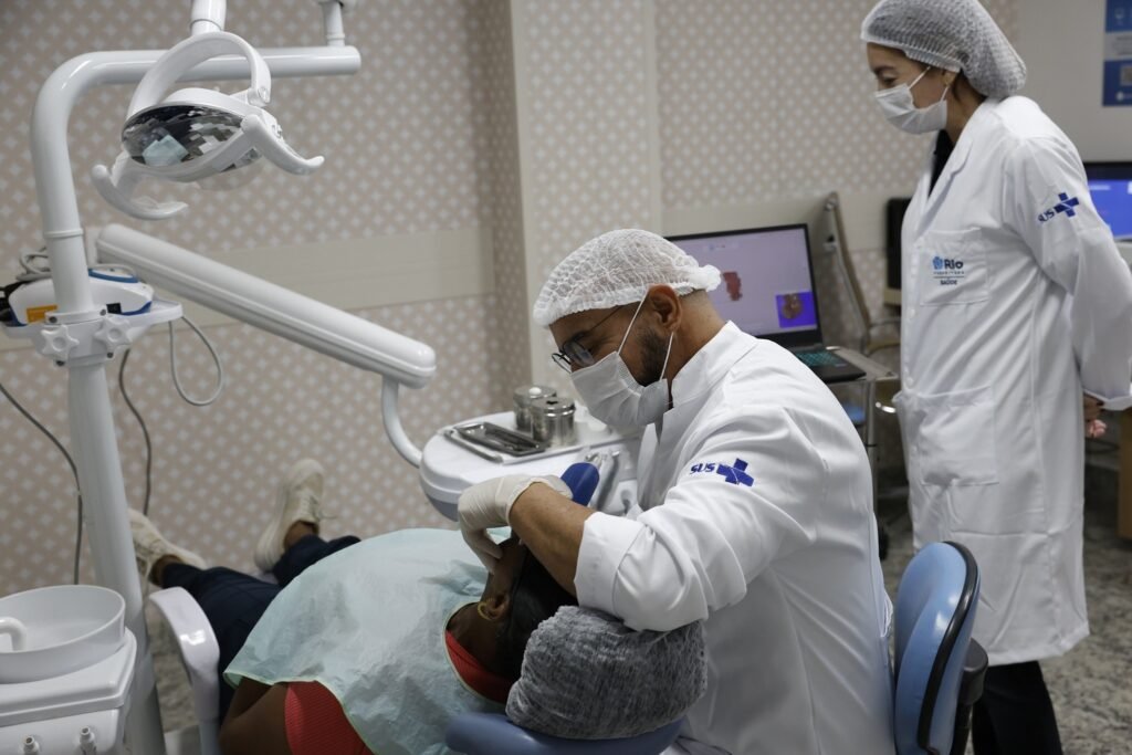 retinopatia diabetica: dentista com jaleco do SUS realiza atendimento em paciente em cadeira odontológica.
