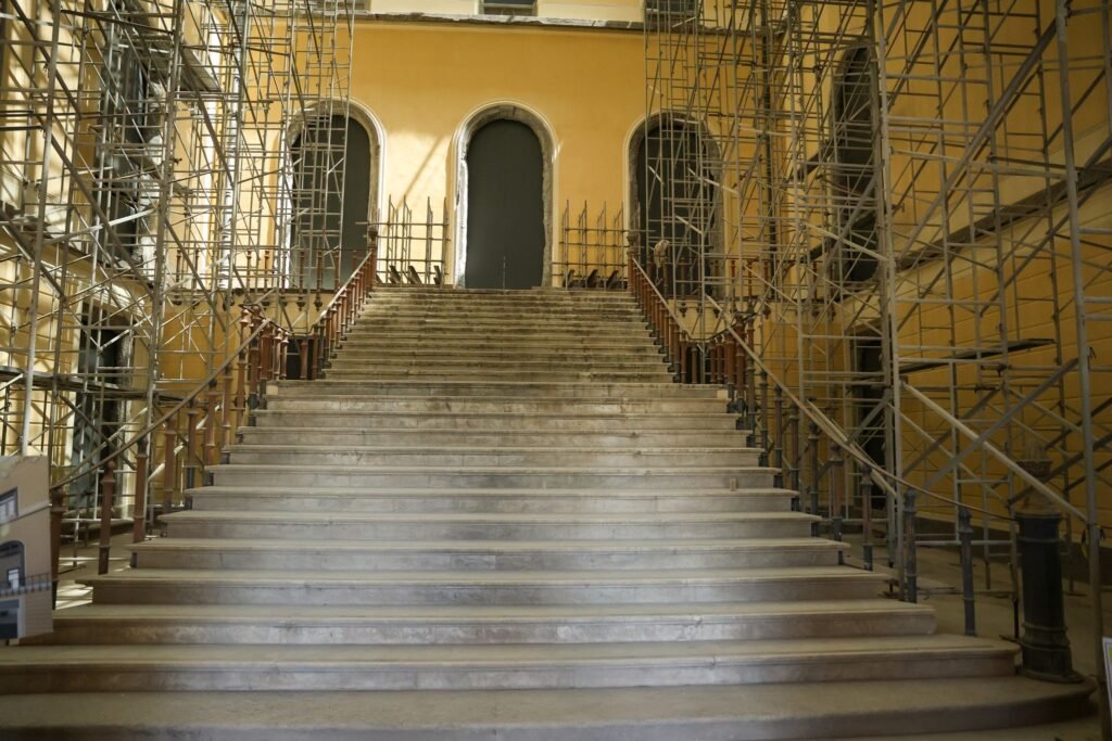 Prédio do museu da ufrj em obras de restauração, cercado por andaimes metálicos.
