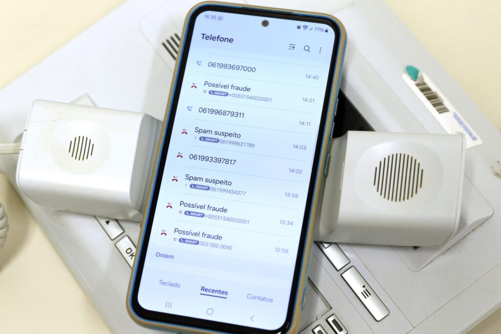 medida provisória: smartphone exibindo histórico de chamadas com avisos de possível fraude e spam.