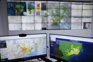 previsão do tempo: Sala de Situação do Cemaden com painel exibindo mapas de risco de desastres naturais.