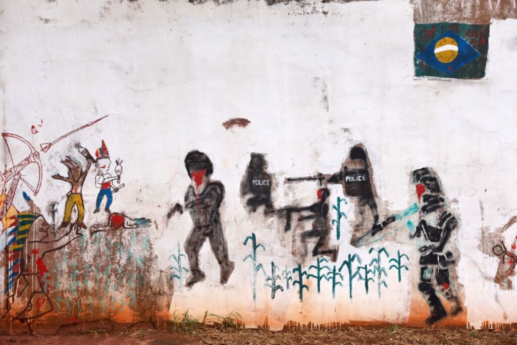 Mural artístico retrata conflito agrario e ataques contra indigenas no Mato Grosso do Sul.