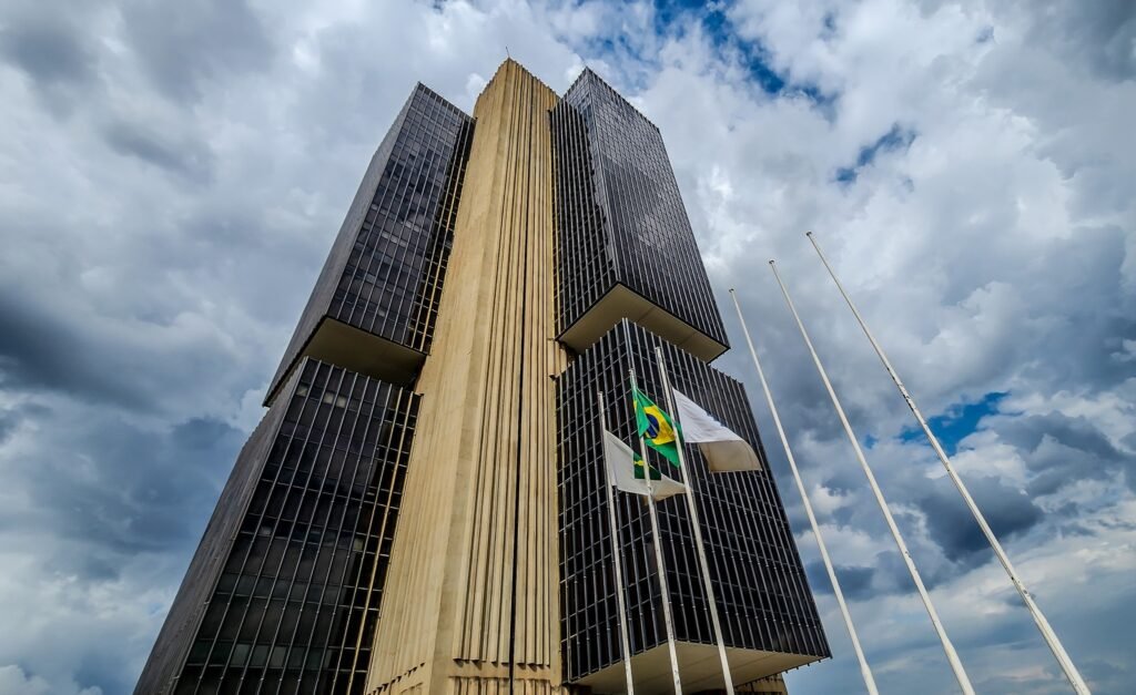 superendividados no brasil: vista inferior do prédio do Banco Central em Brasília sob céu nublado.