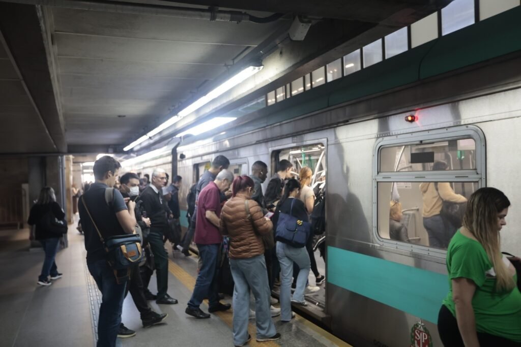 transporte gratuito: passageiros embarcam em um trem na plataforma de uma estação.