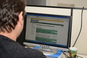 Smart Sampa: homem de costas observa tela de computador com sistema de monitoramento.