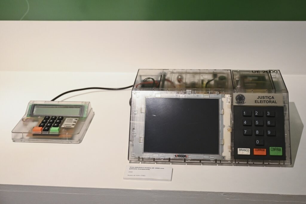 Urna eletrônica modelo "UE-2000" com gabinete transparente exposta no Museu do Voto do TSE.