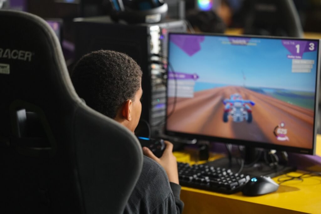 Marco Legal dos Jogos Eletrônicos: menino sentado em cadeira gamer jogando em um computador.