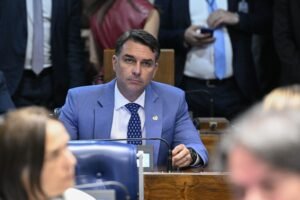Senador Flávio Bolsonaro sentado à bancada no Plenário do Senado Federal.