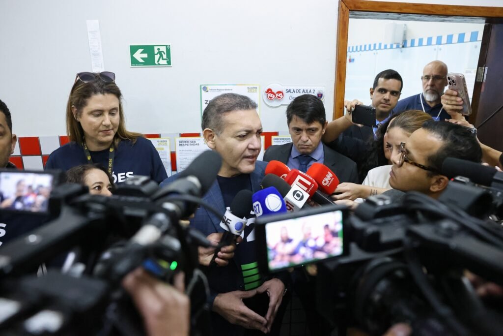 transporte de eleitores indigenas: O ministro Kassio Nunes Marques fala cercado por jornalistas e microfones em ambiente interno.