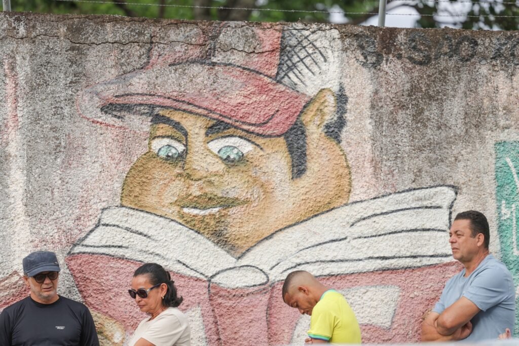 local de votação: eleitores aguardam em fila diante de um muro com grafite em Brasília.