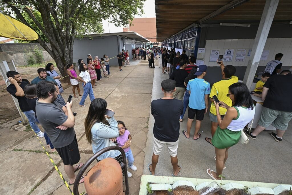 Eleitores aguardam em filas no pátio de escola em Brasília no segundo turno das eleições.