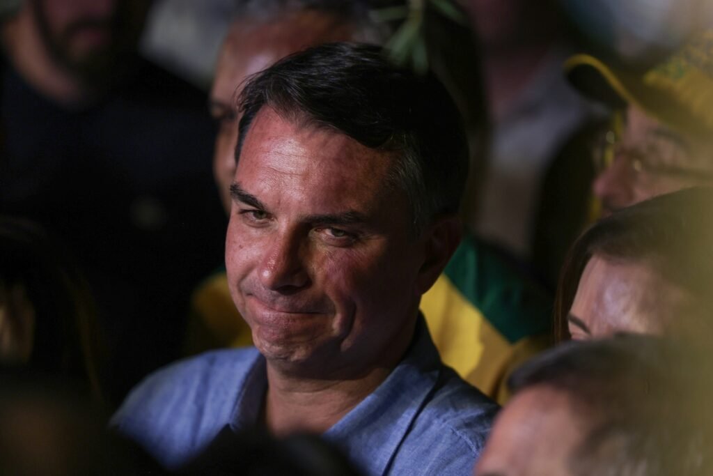 Flávio Bolsonaro em meio a apoiadores durante evento político.