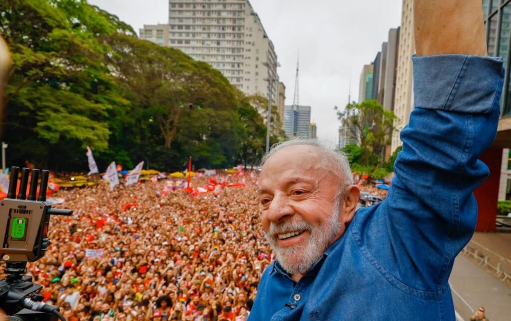 Luiz Inácio Lula da Silva sorri e levanta o braço em meio a uma multidão na Avenida Paulista, em São Paulo.