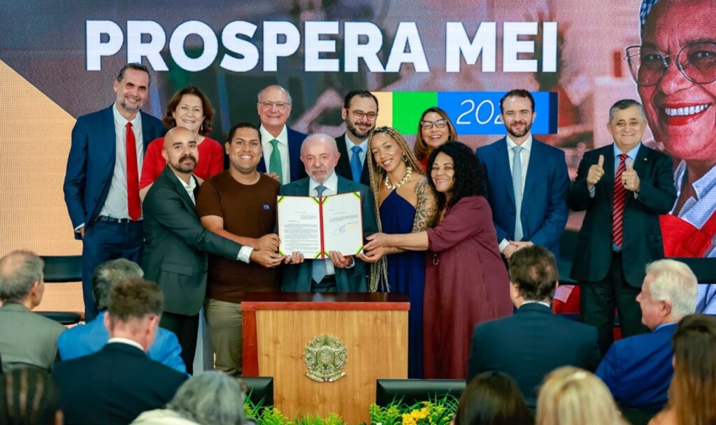 perdao de dividas de MEIs: Presidente Lula e autoridades em cerimônia oficial com painel Prospera Mei.