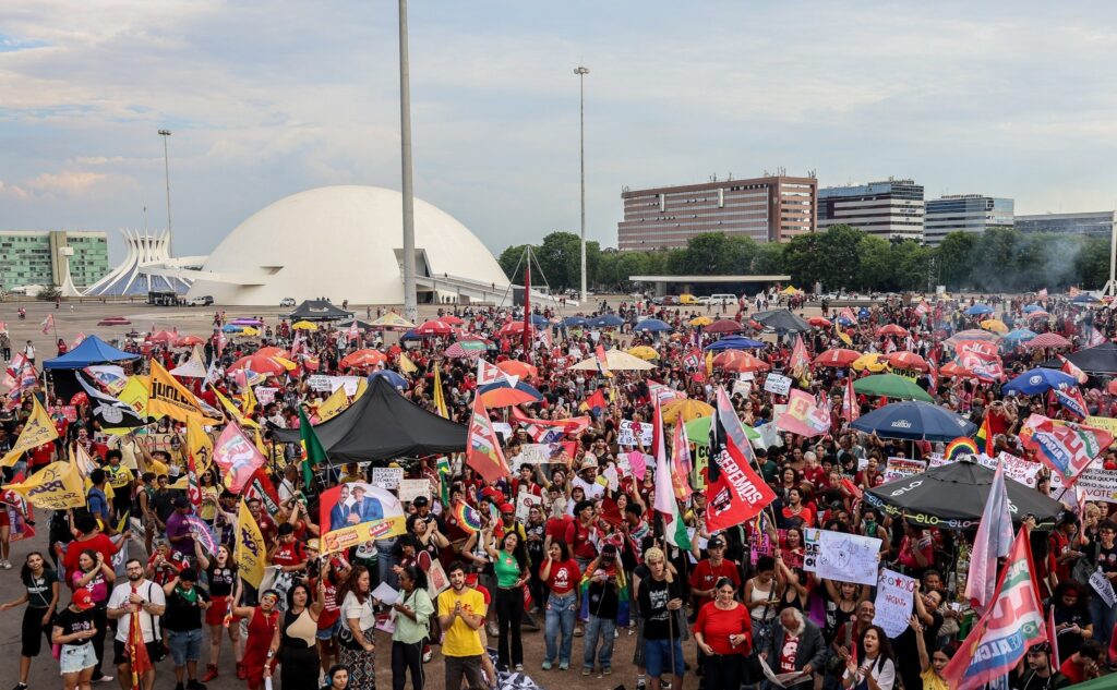 propostas para a Presidência: Grande multidão de manifestantes reunida na Esplanada dos Ministérios, em Brasília, segurando bandeiras e cartazes.