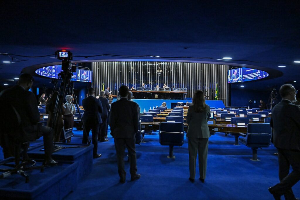 Plenário do Senado Federal com parlamentares e público assistindo à sessão, vista a partir dos fundos do salão.