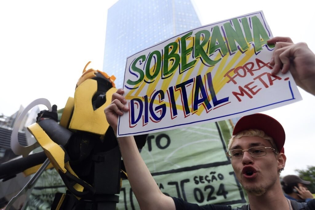 Manifestante segura cartaz com os dizeres 'Soberania Digital' em ato cobrando neutralidade da Meta em São Paulo.