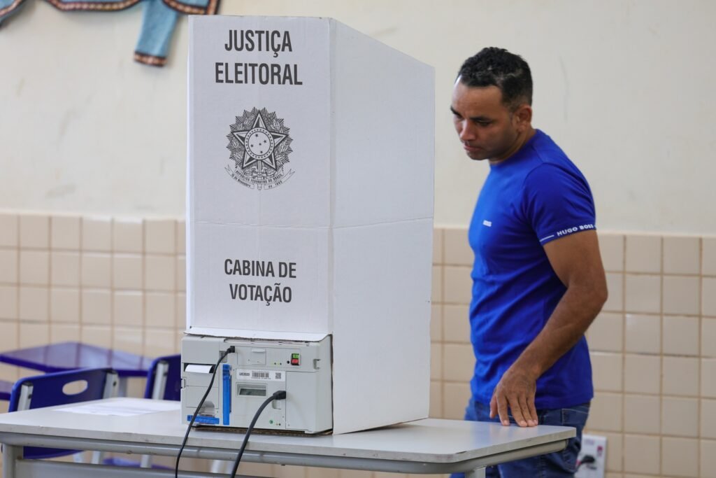 Vicentinho Junior: Eleitor posiciona-se junto a uma cabina de votação com urna eletrônica.