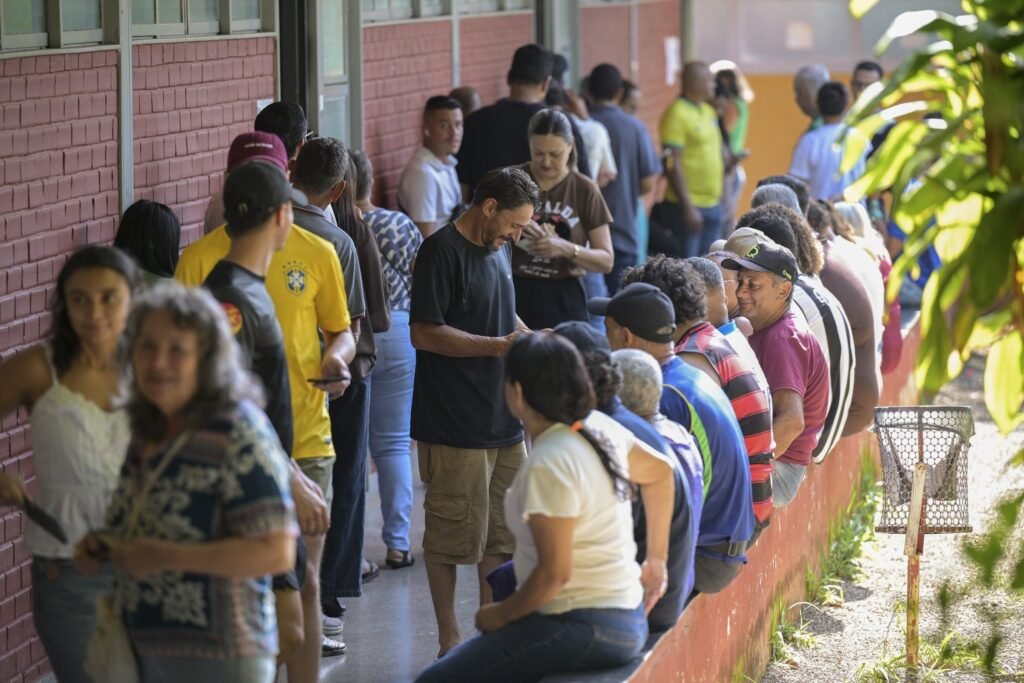 transporte de eleitores: Eleitores aguardam em longa fila para votação em seção eleitoral ao ar livre.
