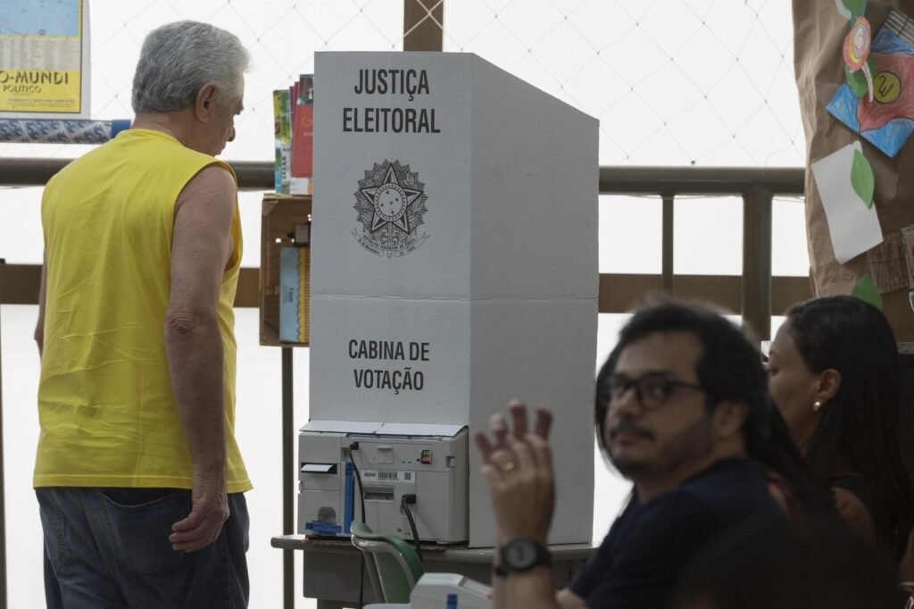 Eleitor ao lado de cabina de votação da Justiça Eleitoral em uma das secoes eleitorais.