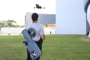 violencia politica: Agente da Polícia Federal observa drone em voo sobre gramado corporativo.