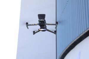 desmatamento: drone cinza da Polícia Federal em voo diante de estrutura arquitetônica externa.