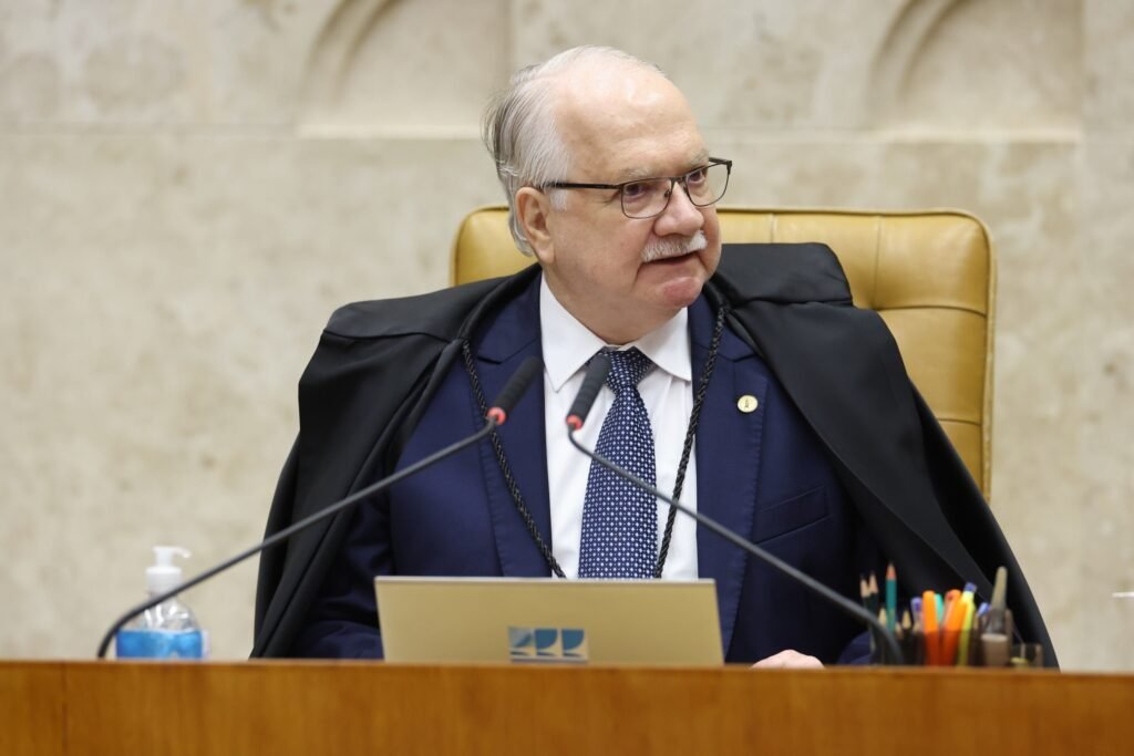 O ministro Edson Fachin participa de sessão plenária do Supremo Tribunal Federal, sentado à bancada com microfones e notebook.