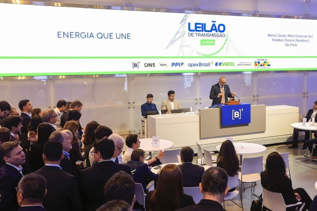 alta do dólar: Auditório da B3 durante leilão de transmissão de energia, com homem discursando na tribuna.